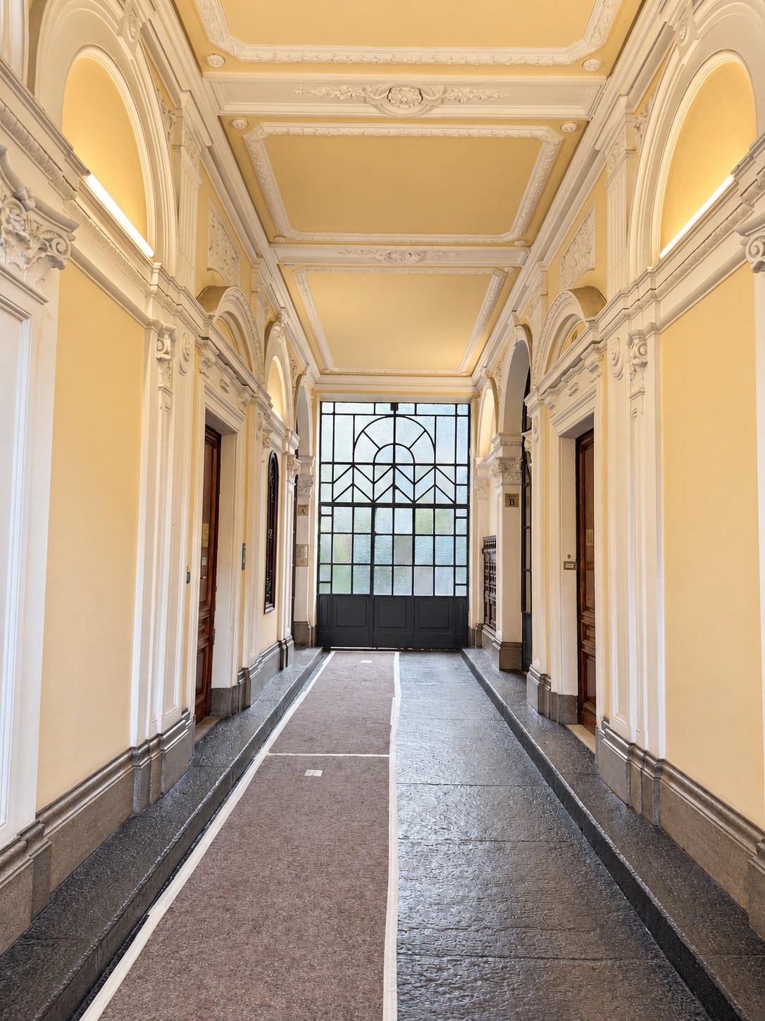 L'androne d'epoca del palazzo, con volte decorate e vetrata sul cortile