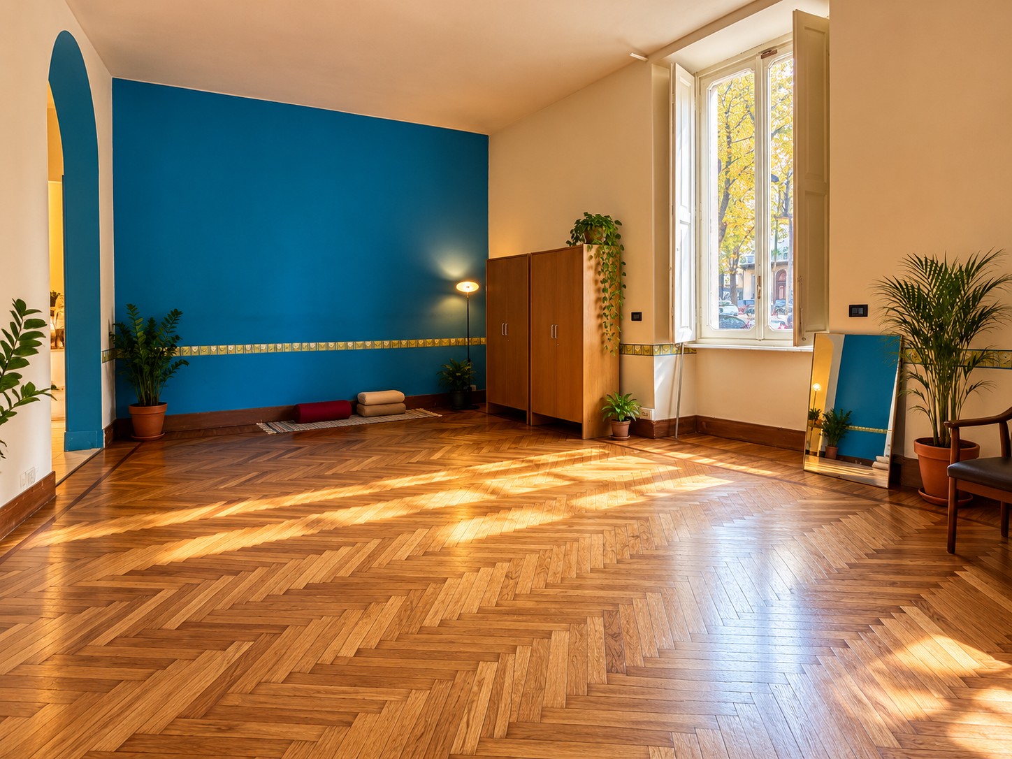 Il salone, ampio e luminoso, con parquet a spina di pesce e finestra alta